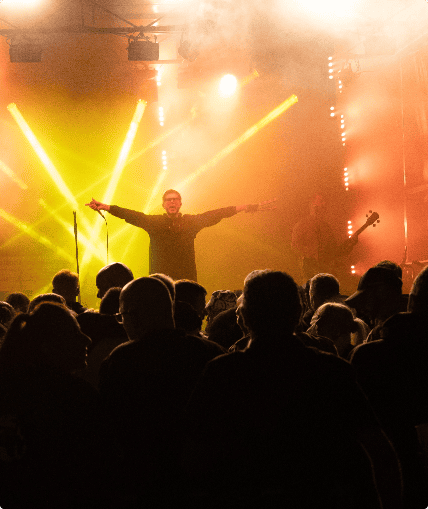 Group of people watching a performance by a musical artist