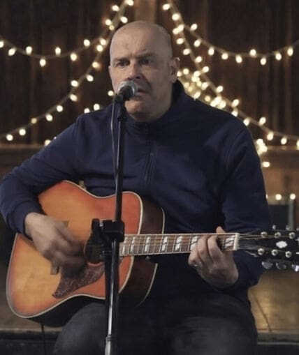 Musical performer on stage with guitar