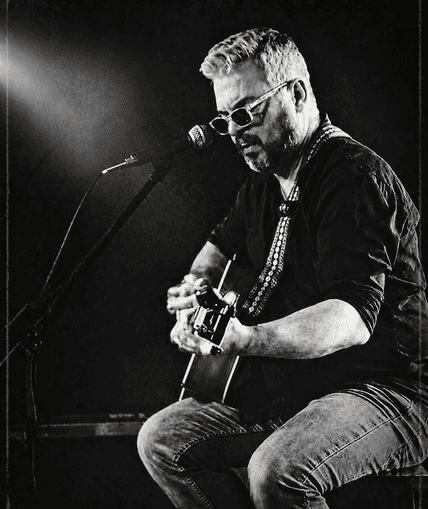 Musical performer on stage with guitar